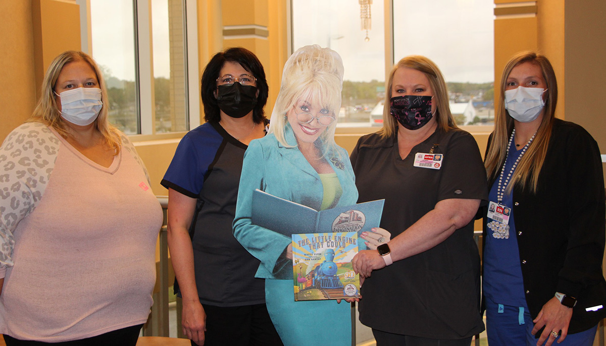 Nursing staff standing with cut out of Dolly Parton for group photo